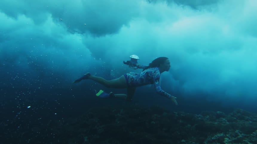 A woman swims under dark ocean waves