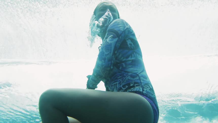 A woman floats below the ocean waves