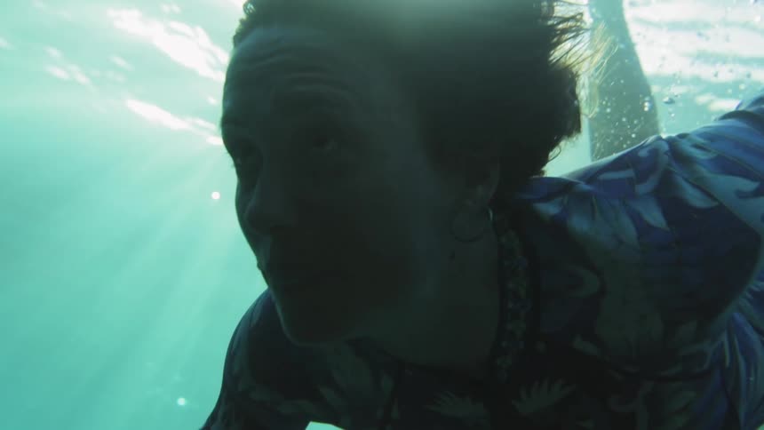 A woman looks ahead through clear eerie waters