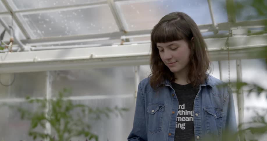 A woman is browsing around a greenhouse