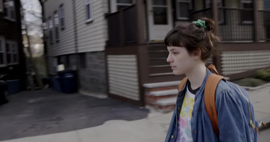 A woman is walking down a residential street