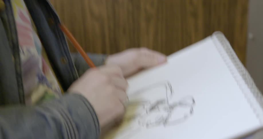 A woman is drawing in a pad