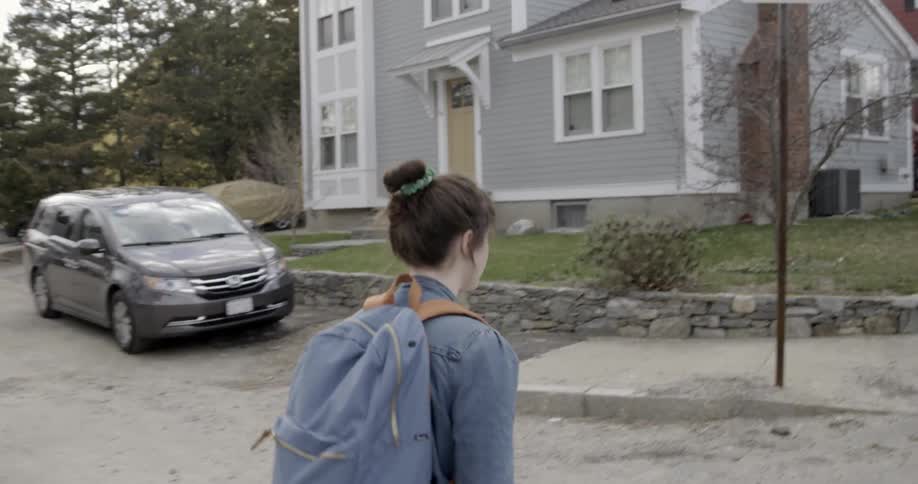 A woman with her hair in a bun walks down the street