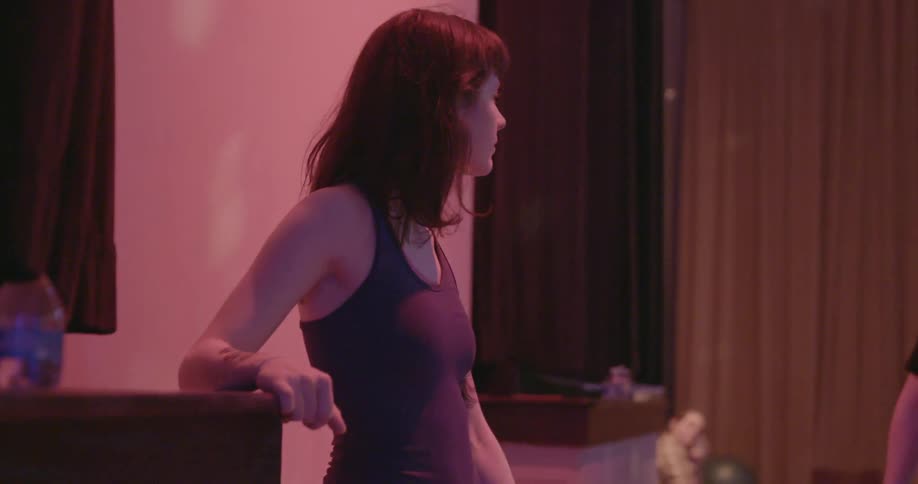 A woman is standing near a wall with lights flashing all over