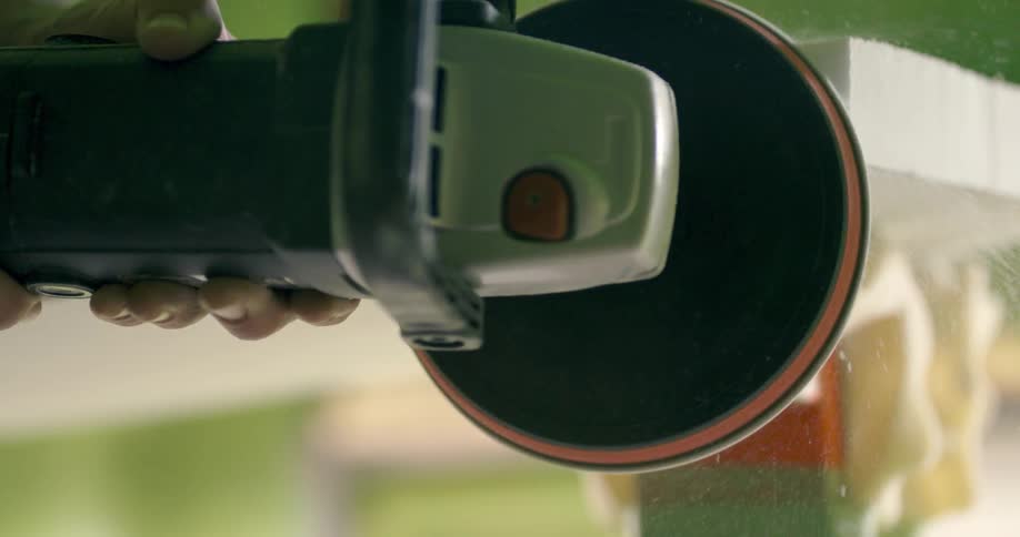A man uses a tool to shave wood