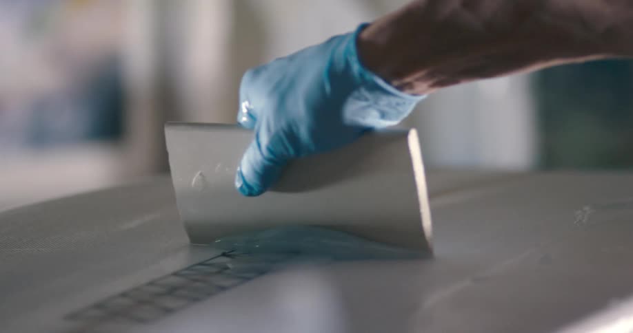 A man applying a protective coating on an item