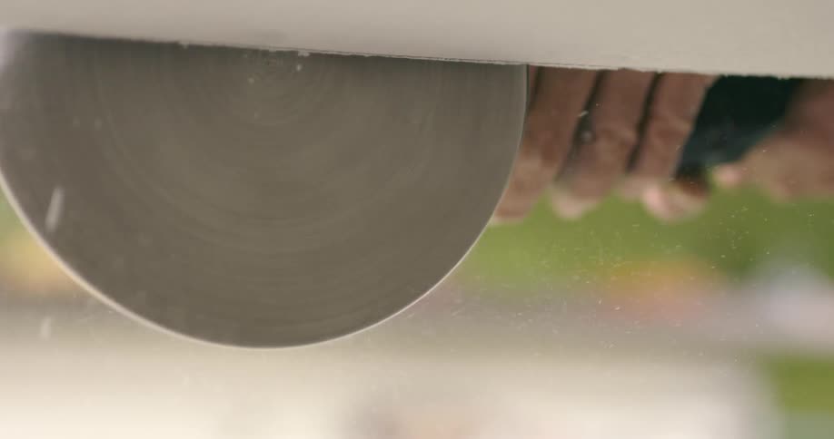A person using a power tool to sand a board