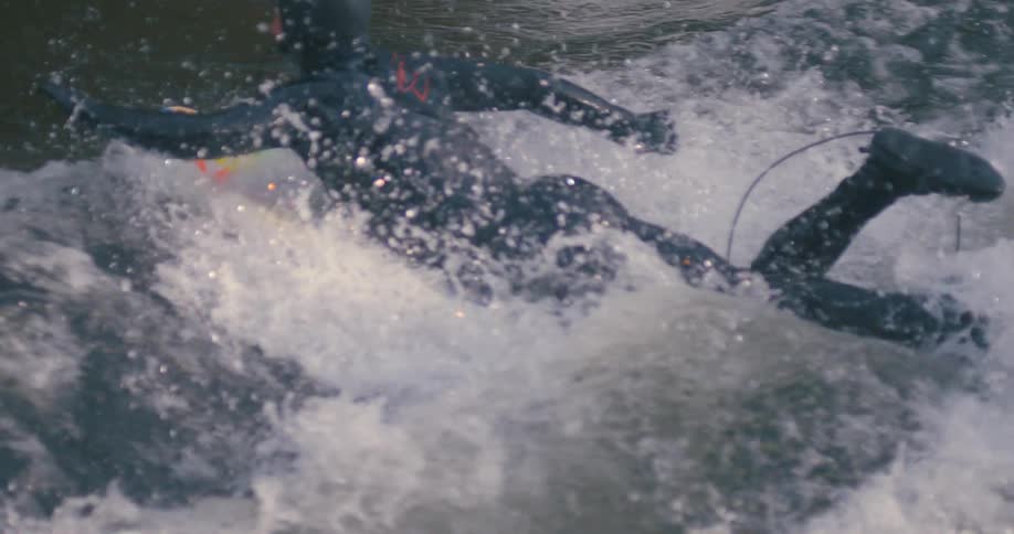 Waves crashing over a surfer in a wet suit