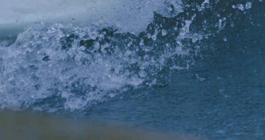 Person balances on surfboard riding crashing wave