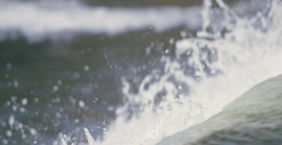 Strong white waves rush through dark green waters