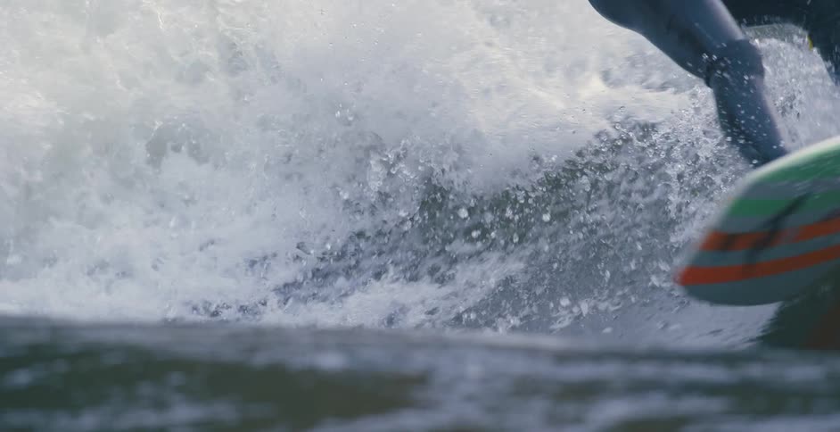 Surfer rides a surfboard over the waves of a wave pool