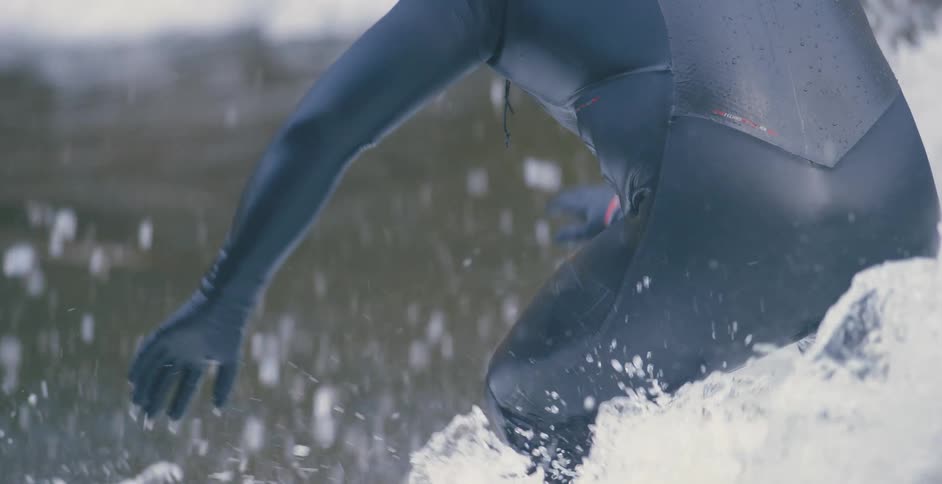 Close up water splashing as a man surfs and then him falling