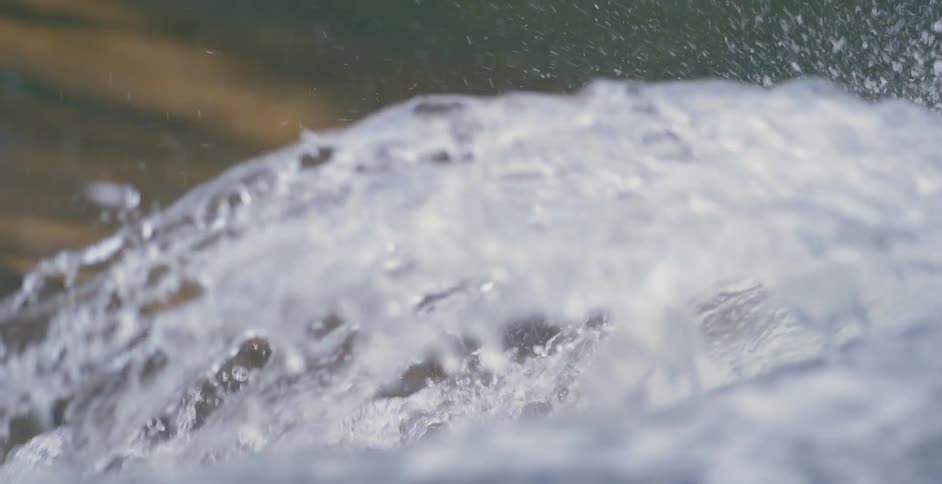 A surfer in a wet suit rides a wave on the ocean during the day