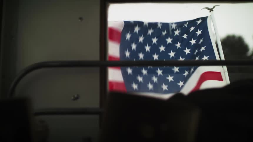 United states flag flying outside of window