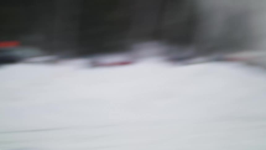 People watch as a car races in the snow