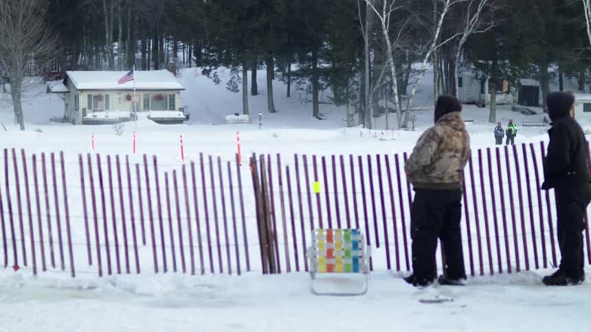People watching cars racing in the snow