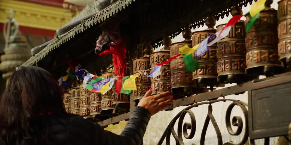 A woman spins small barrels as she walks past them