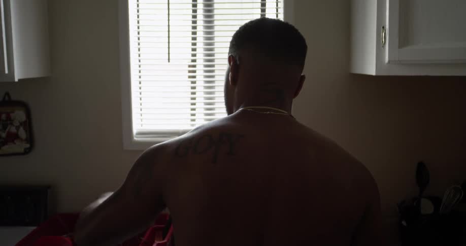 A man is washing dishes near a window