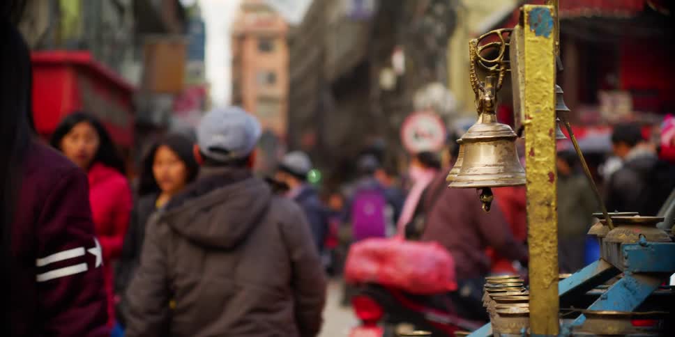 Pedestrians walking between the traffic on a busy city street in asia