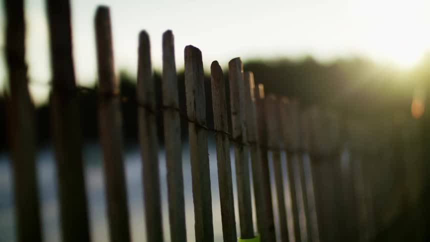 The sun shining over a rural wood fence