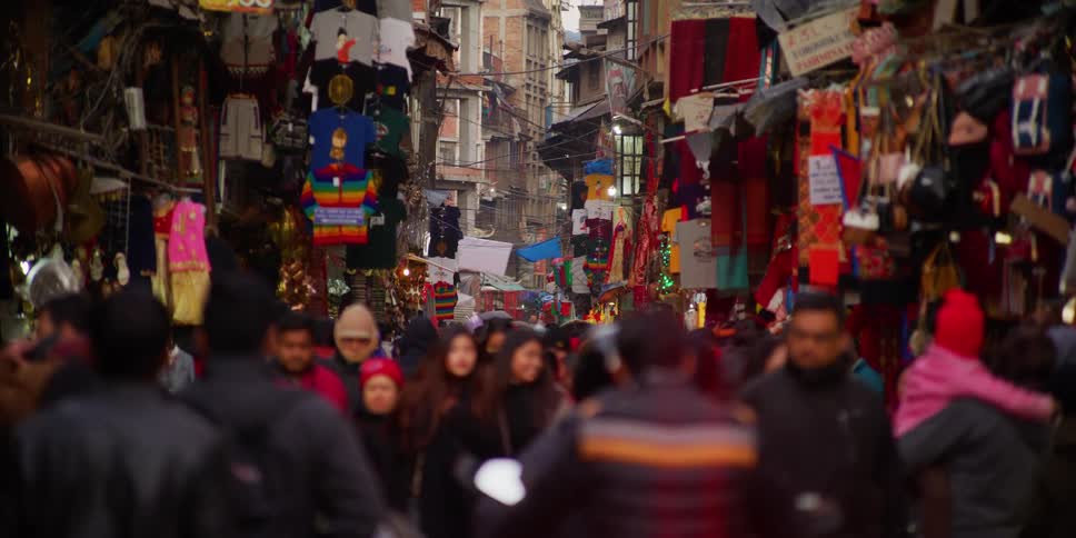 A city street with people walking with buildings in the background