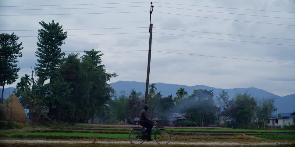 A man cycles down a neighborhood street