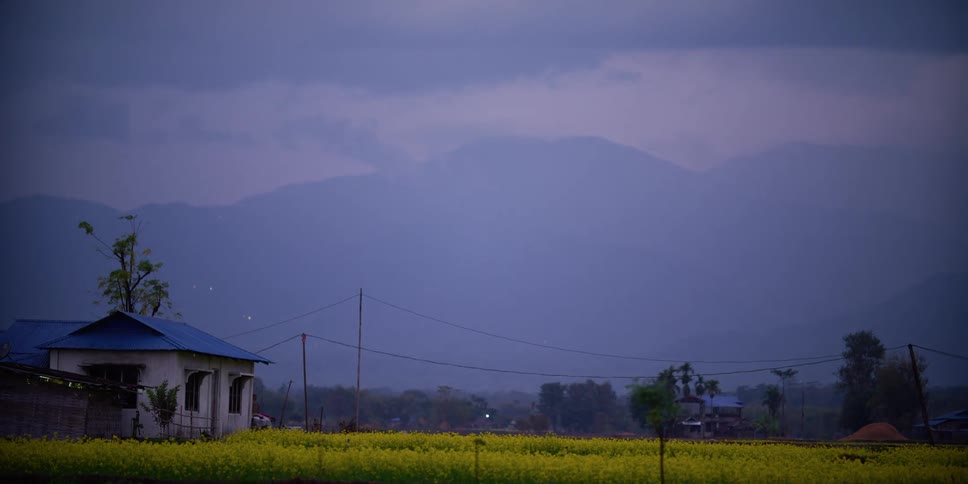 House in a field near the mountains at sunset
