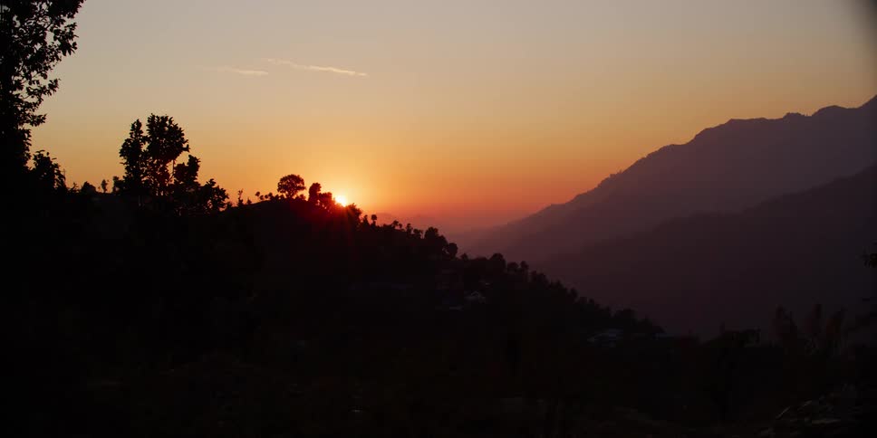A view of the sun setting in the horizon is displayed