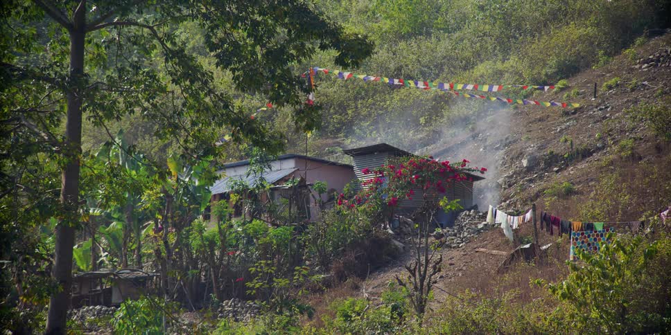 Smoke coming out of the backyard of a slum house in a hill
