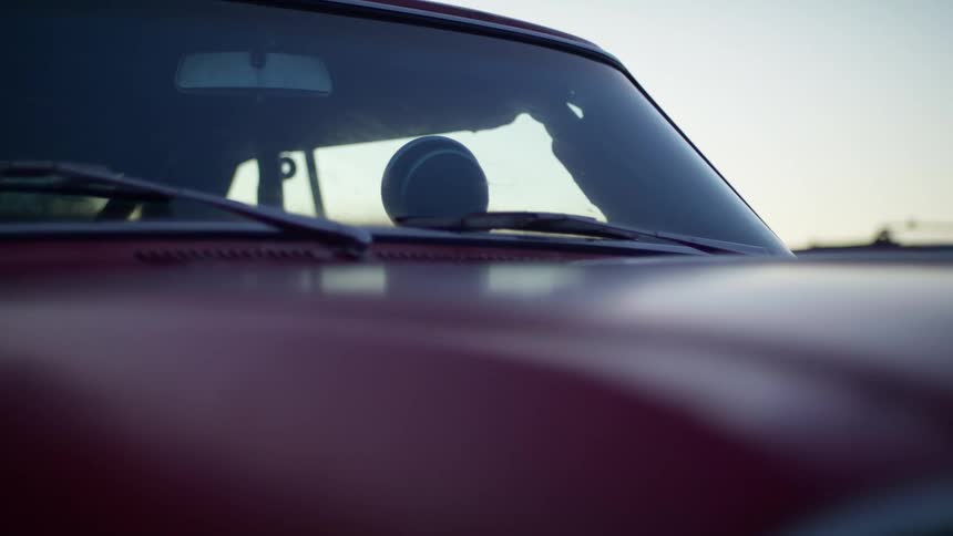 Close up of the windshield of a red race car at sunset