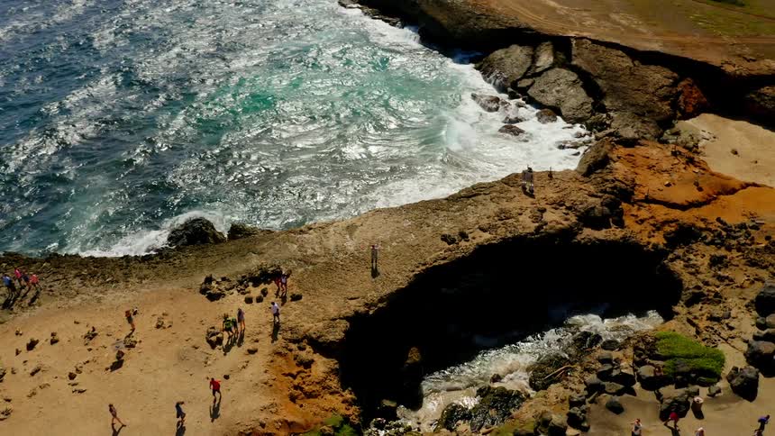 Several people are walking on land near the beach