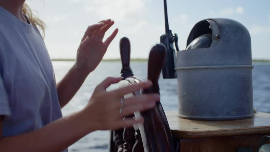 A woman steering a boat in the ocean