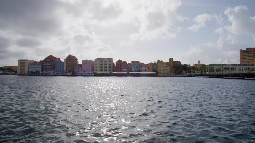 Sunshine reflects in the water of a river surrounding a city