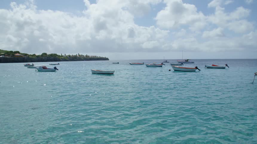 Motor boats floating on the calm blue waters of the ocean near the coast