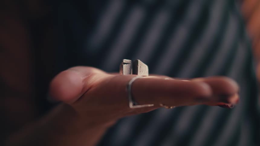 Woman holds metallic silver chunks in her up turned palm