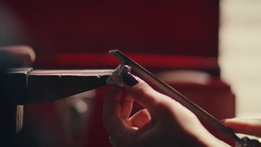 A woman using a tool to file a rock
