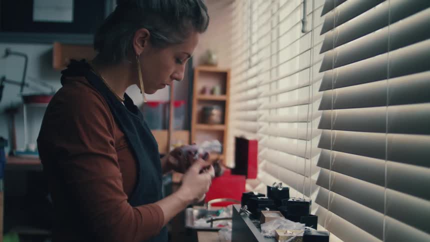 A jeweler in a store looks at her inventory