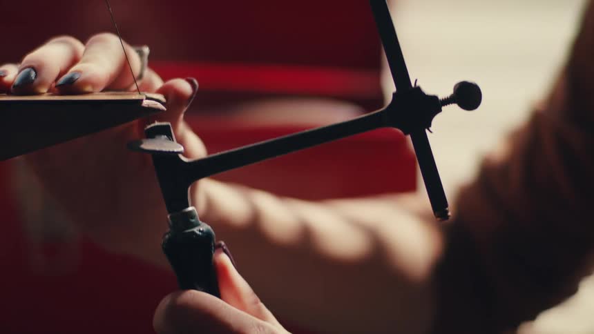 A woman using a hand saw indoors