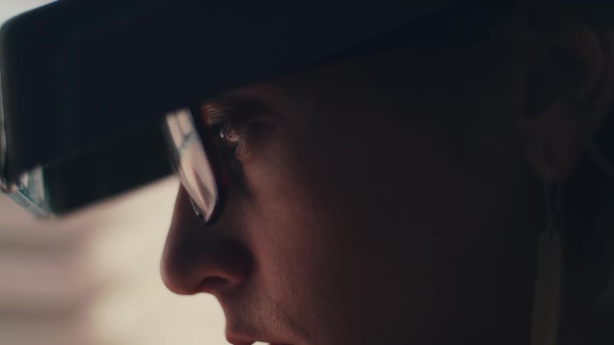 A man with an earring is wearing a hat