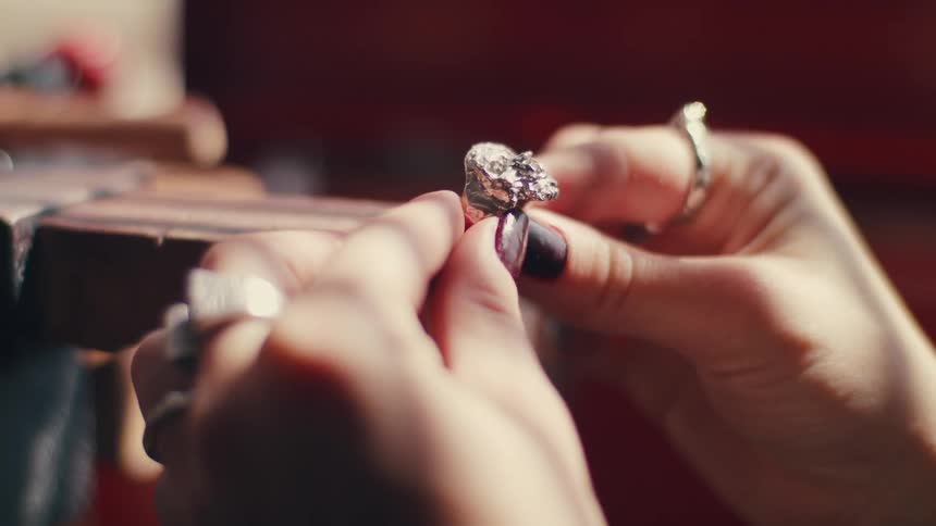 A woman putting a ring on a piece of wood