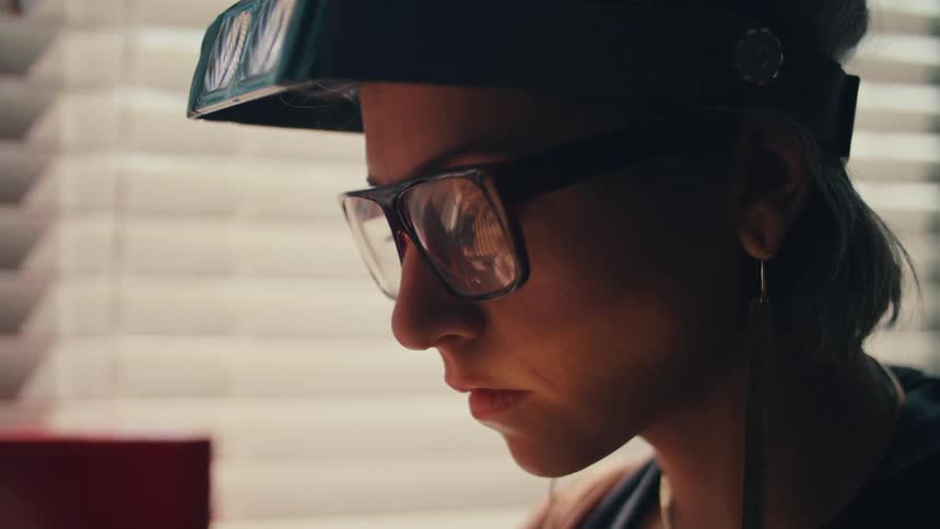 A teenage girl at home lowers virtual reality glasses over her eyes