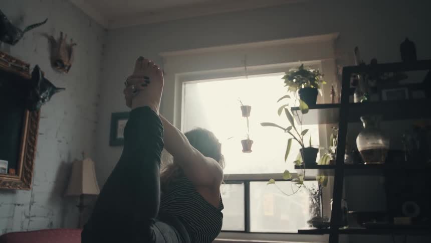 A woman is stretching in her house