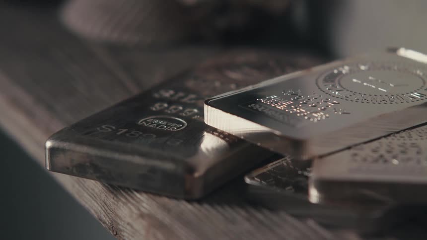 Bars of silver sitting on a wood shelf