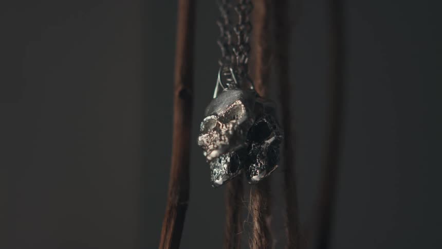 Three metal skulls hang from a chain