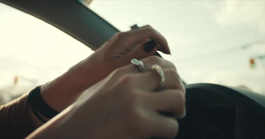 A woman is driving a car at dusk
