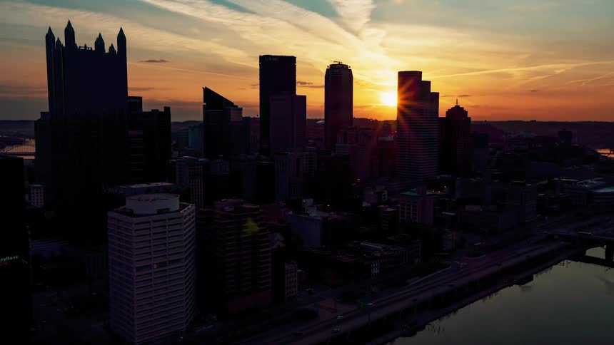 Skyscrapers bordering a river in a metropolis at sunset