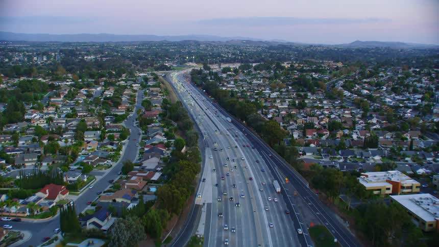 An aerial view of cars driving on a highway is displayed
