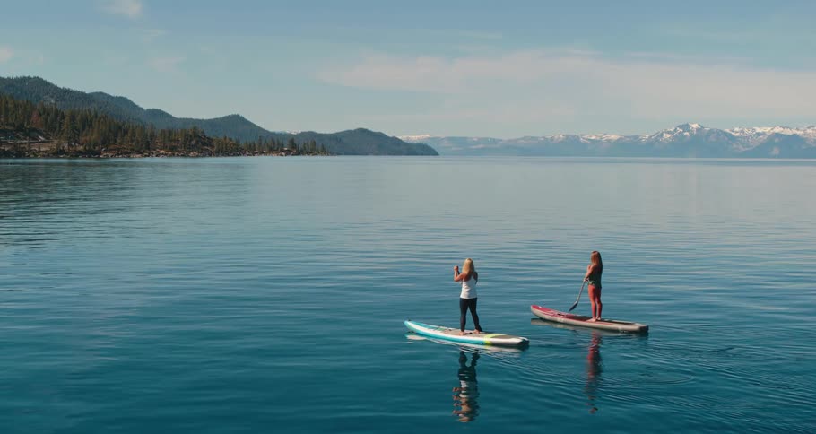 Two women paddle boarding in a lake