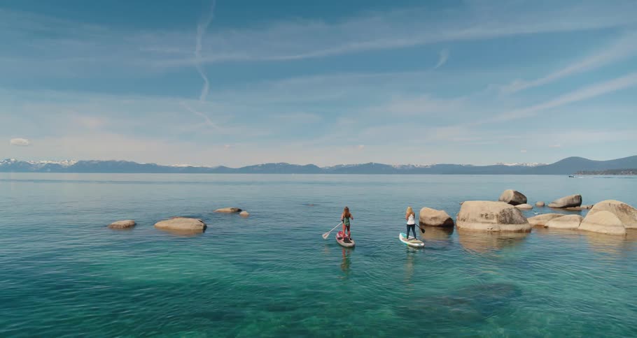 Two women paddle boarding in a lake
