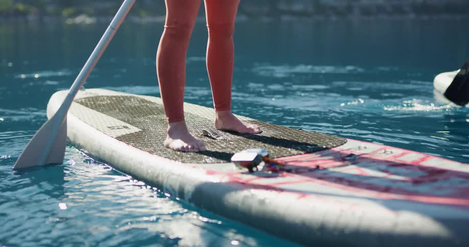 Two women use paddle boards in a lake but one womans board does not move